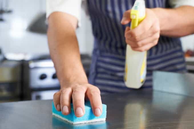 chef sanitizing kitchen counter