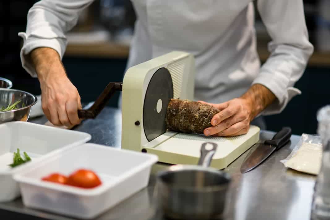 chef using a meat slicer